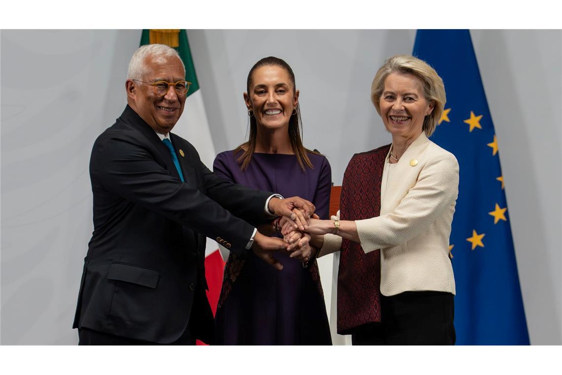 Claudia Sheinbaum (M), Präsidentin von Mexiko, EU-Ratspräsident Antonio Costa (l) und die EU-Kommissionspräsidentin Ursula von der Leyen halten sich bei einer Pressekonferenz im Präsidentenpalast die Hände, nachdem ein Handels- und Partnerschaftsabkommen unterzeichnet wurde.