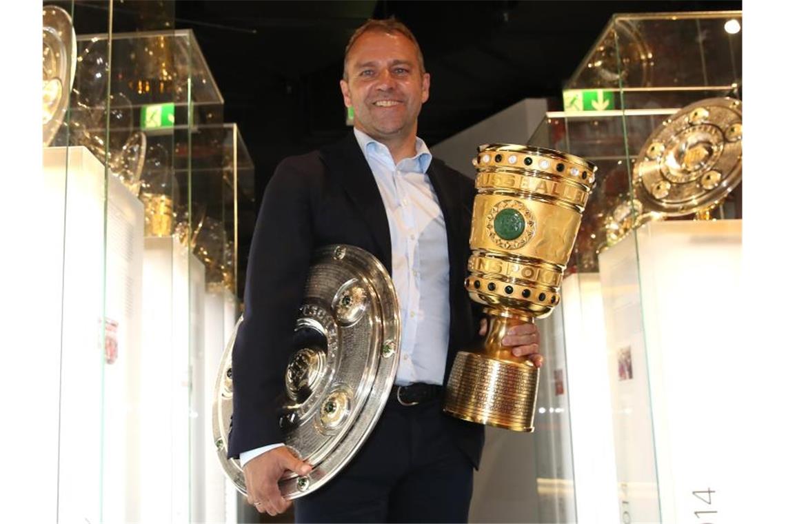 Coach Hansi Flick übergibt die Meisterschale und den Pokal an das Museum des FC Bayern München. Foto: Alexander Hassenstein/Getty Images Europe/FCB/dpa