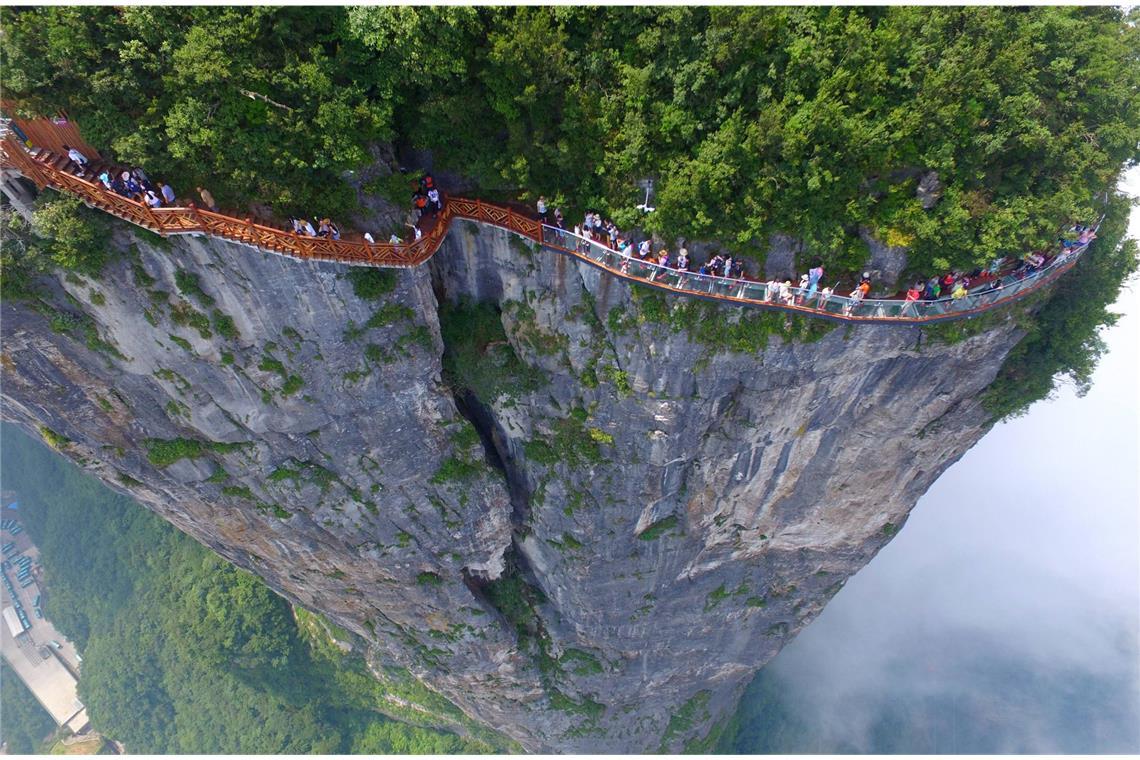 „Coiling Dragon Cliff Skywalk“ heißt dieser Höhenweg, was so viel wie „Gewundener Drachenfelsen-Himmelsstraße“ bedeutet. In 99 Kurven schlängelt sich der Glasweg durch den  Zhangjiajie National Forest Park.