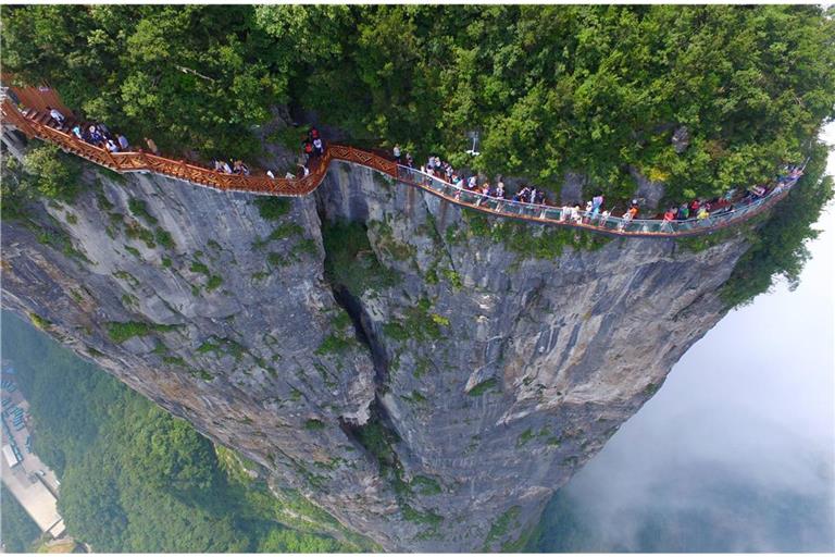 „Coiling Dragon Cliff Skywalk“ heißt dieser Höhenweg, was so viel wie „Gewundener Drachenfelsen-Himmelsstraße“ bedeutet. In 99 Kurven schlängelt sich der Glasweg durch den  Zhangjiajie National Forest Park.