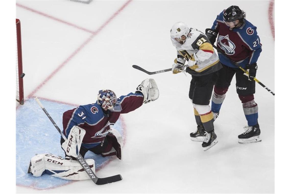 Colorados Torhüter Philipp Grubauer (l) mit Ryan Graves (r) in Aktion gegen Jonathan Marchessault von den Vegas Golden Knights. Foto: Jason Franson/The Canadian Press/AP/dpa