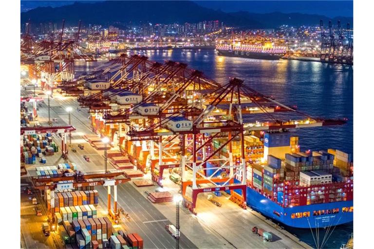 Containerschiffe liegen im nächtlich beleuchteten Containerterminal des Hafens von Qingdao. Foto: Yu Fangping/SIPA Asia via ZUMA Wire/dpa