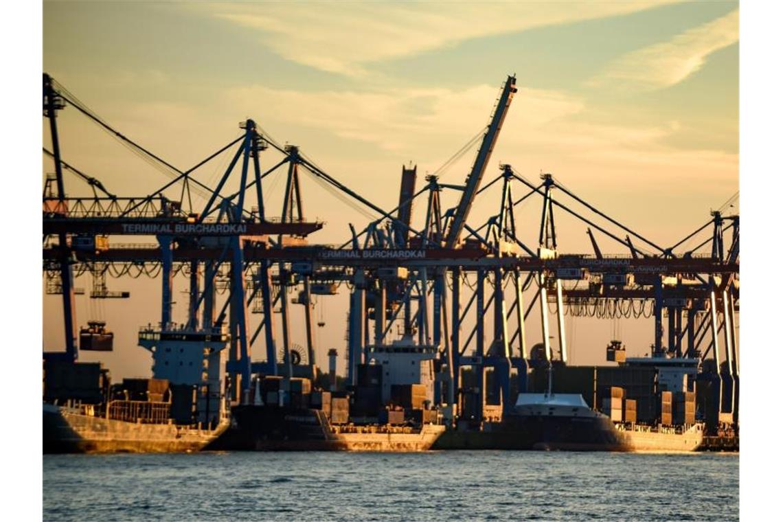 Containerschiffe werden im Hafen bei untergehender Sonne abgefertigt. Deutschland ist laut einer Untersuchung des bayerischen Unternehmerverbands vbw eines der Länder mit den besten Bedingungen für Industrieunternehmen weltweit. Foto: Axel Heimken