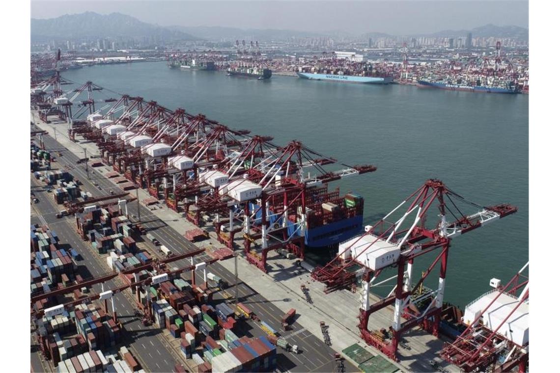 Containerschiffe werden in einem Containerhafen in Qingdao angedockt. Als Zeichen für eine anhaltende wirtschaftliche Erholung nach Überwindung der Corona-Pandemie hat Chinas Außenhandel erneut zugelegt. Foto: Uncredited/CHINATOPIX/AP/dpa