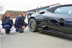 Corinne Peterolff und Oliver Schäfer kontrollieren einen schwarzen Lamborghini. Foto: Tobias Sellmaier