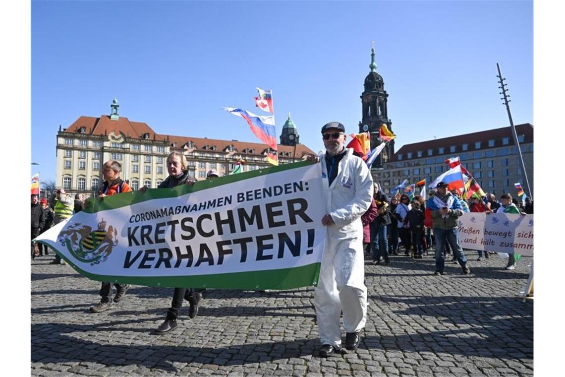 Corona-Gegner schwenken Russland-Fahnen bei Demo in Dresden „Coronamaßnahmen beenden: Kretschmer verhaften!“ fordern etwa diese Teilnehmer. Im Hintergrund sind mehrere Russland-Fahnen zu erkennen. Foto: Robert Michael/dpa-Zentralbild/dpa