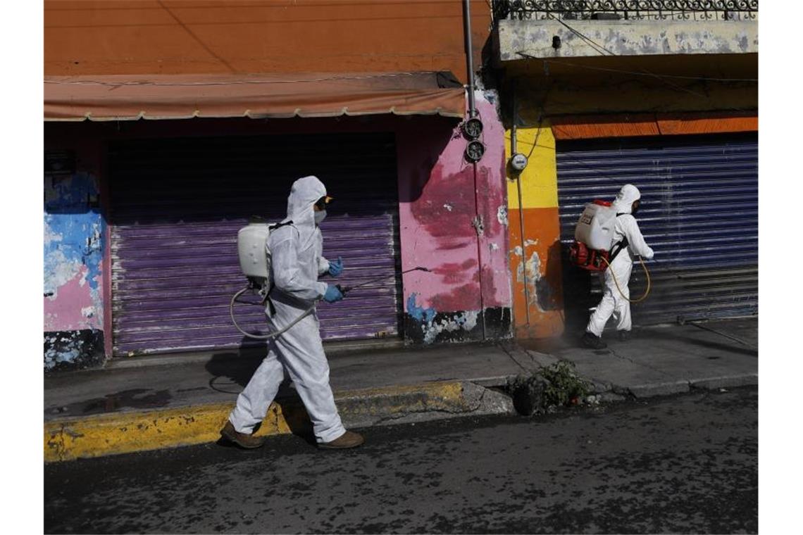 Coronavirus-Pandemie: In Mexiko-Stadt sprühen Arbeiter eine Desinfektionslösung auf die Straße. Foto: Rebecca Blackwell/AP/dpa