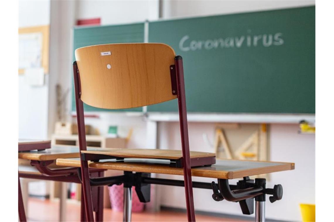 „Coronavirus“ steht auf einer Tafel in einem leeren Klassenzimmer. Foto: Armin Weigel/dpa/Symbolbild