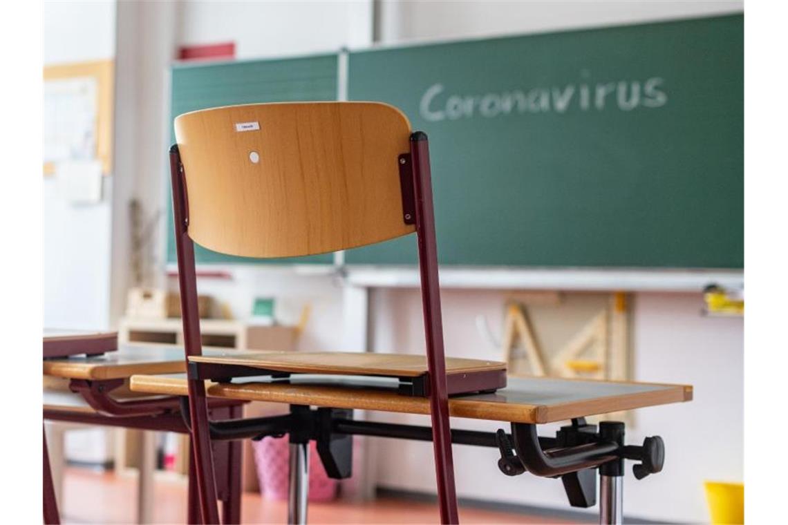 „Coronavirus“ steht auf einer Tafel in einem leeren Klassenzimmer. Foto: Armin Weigel/dpa/Archivbild