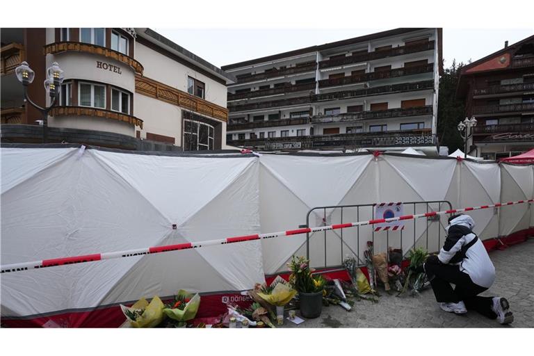 Crans-Montana: Menschen bringen Blumen in der Nähe der abgeriegelten Bar.