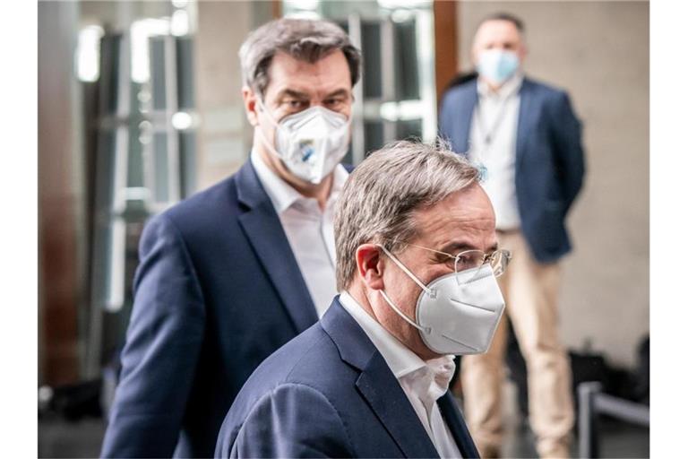 CSU-Chef Markus Söder und der CDU-Vorsitzende Armin Laschet auf dem Weg zu einer Pressekonferenz. Foto: Michael Kappeler/dpa