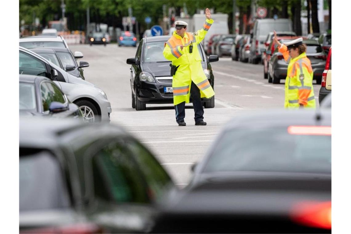 Stromausfall in München: Ermittlungen wegen Brandstiftung Da auch Ampeln ausgefallen sind, regeln Polizisten den Verkehr auf einer Kreuzung. Foto: Matthias Balk/dpa