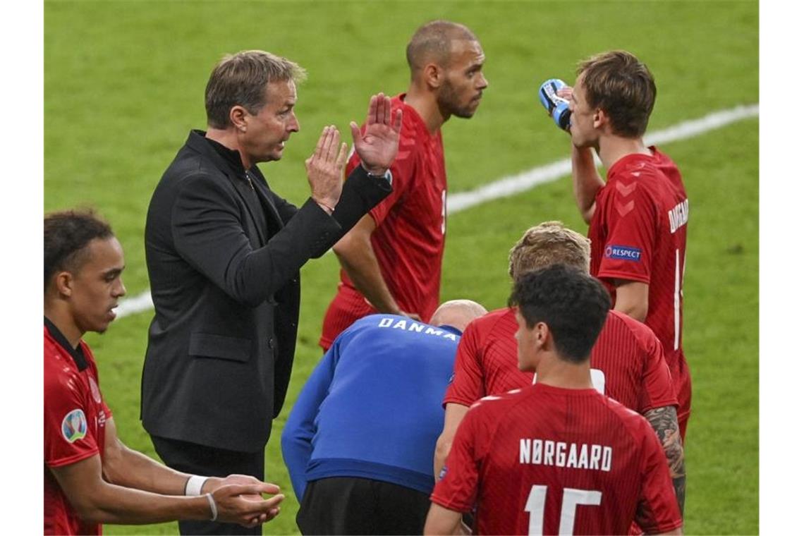 Dänemark-Coach Kasper Hjulmand während einer Trinkpause in Mitte seiner Spieler. Foto: Justin Tallis/Pool AFP/AP/dpa