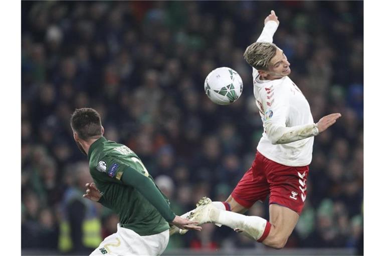 Dänemarks Jens Styger-Larsen (r) und der Ire Edna Stevens kämpfen um den Ball. Foto: Peter Morrison/AP/dpa