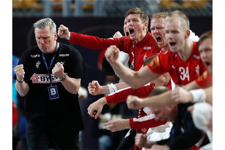 Dänemarks Trainer Nikolaj Bredahl Jacobsen (l) und das Team jubeln an der Seitenlinie. Foto: Petr David Josek/AP/dpa