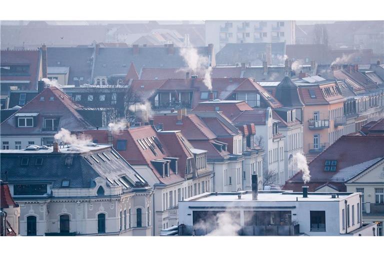 Dampf strömt aus den Kaminen auf den Dächern der Mehrfamilienhäuser im Leipziger Süden an einem kalten Wintermorgen.