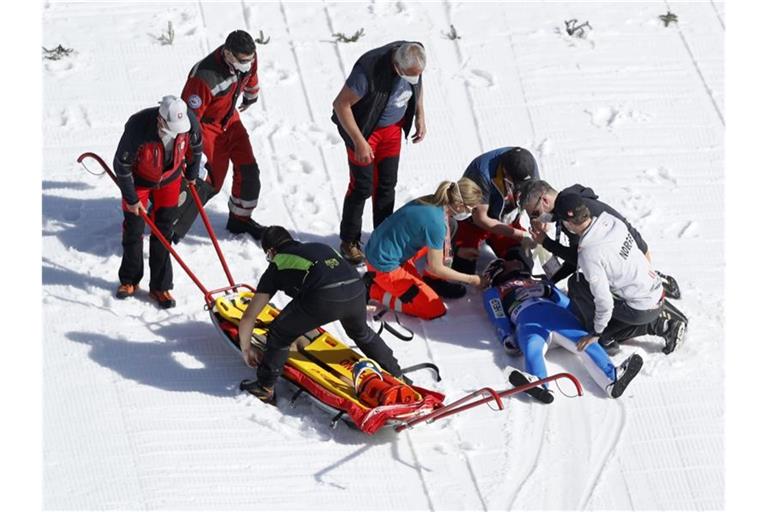 Daniel Andre Tande wird nach seinem schweren Sturz in Planica noch am Unfallort behandelt. Foto: Uncredited/AP/dpa