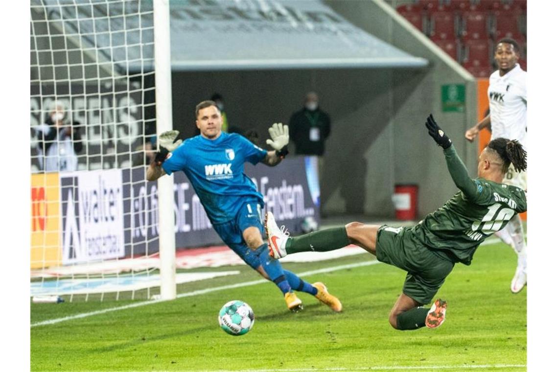 Daniel Didavi vom VfB Stuttgart setzt zum Torschuss an und trifft. Torwart Rafal Gikiewicz vom FC Augsburg kann den Ball nicht abwehren. Foto: Matthias Balk/dpa