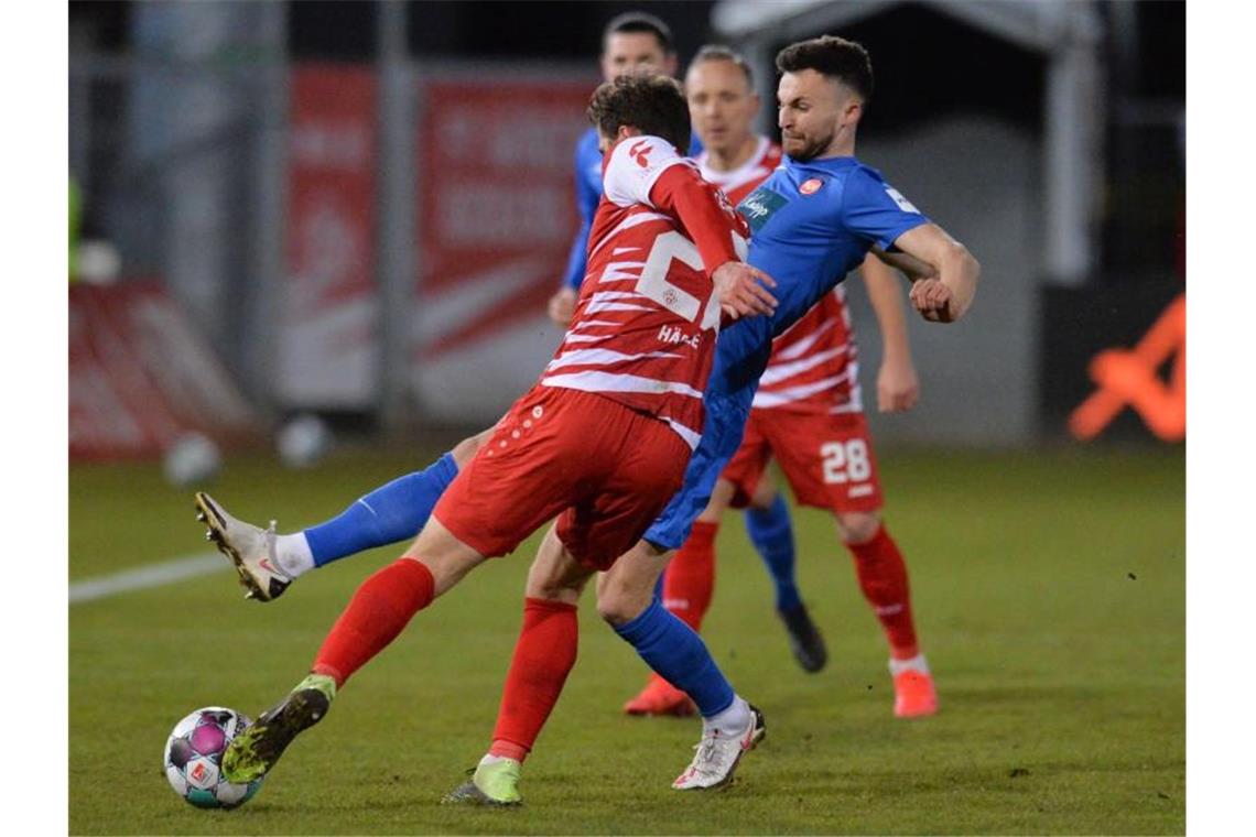 Heidenheim gewinnt in Würzburg Daniel Hägele (l) von den Würzburger Kickers spielt gegen Denis Thomalla vom 1. FC Heidenheim. Foto: Timm Schamberger/dpa
