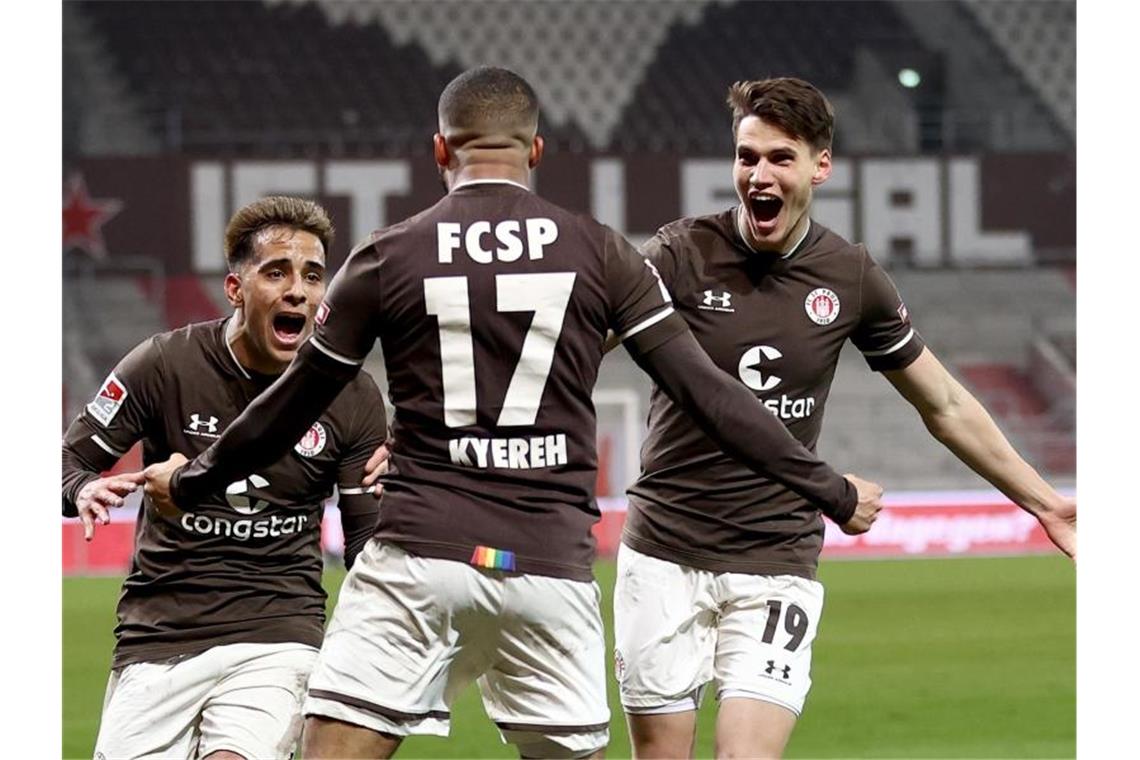 Daniel-Kofi Kyereh (M) feiert seinen Treffer zum 1:0 für den FC St. Pauli gegen den HSV mit Rodrigo Zalazar und Luca Zander (r). Foto: Christian Charisius/dpa-Pool/dpa