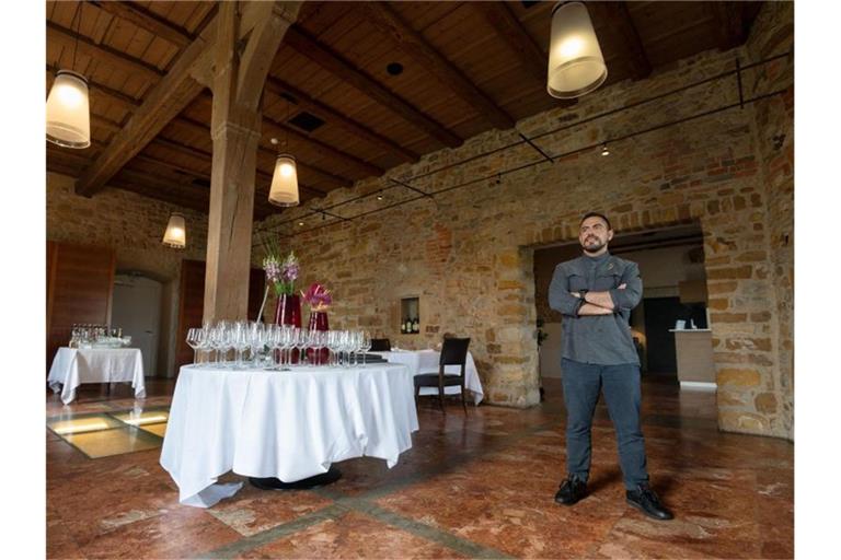 Daniele Corona, Küchenchef im Restaurant Schloss Filseck, steht neben einem Tisch des Restaurants. Foto: Marijan Murat/dpa