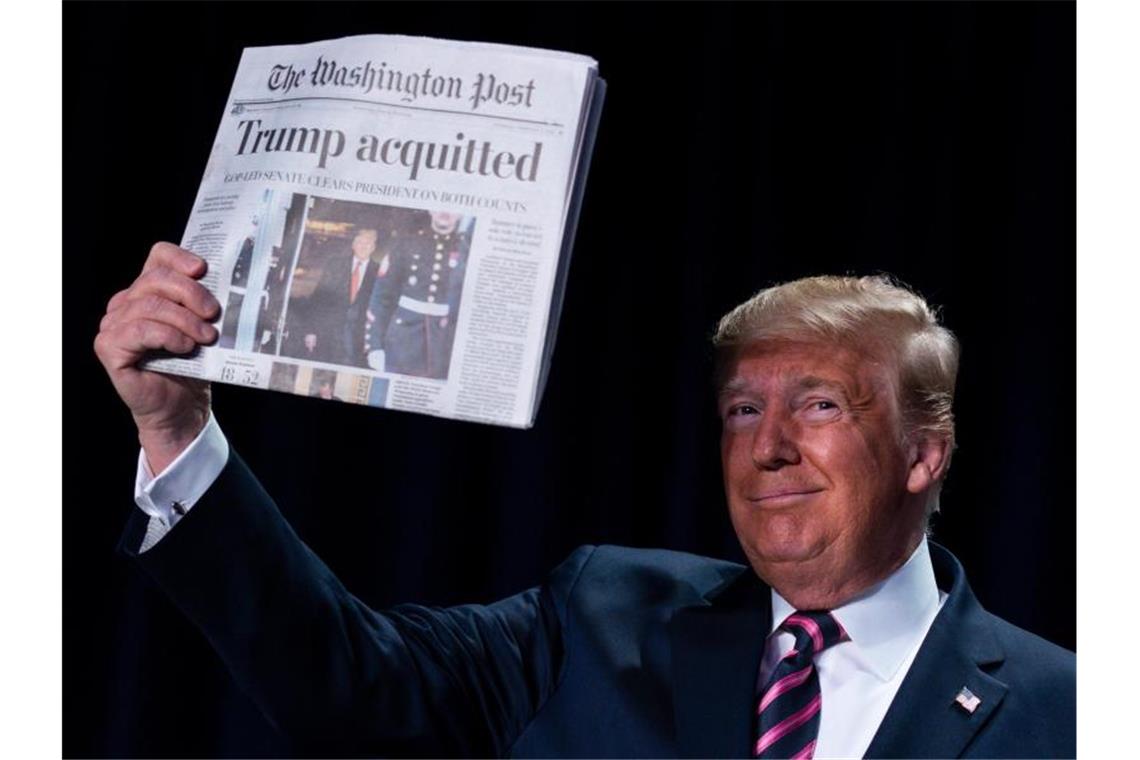 Dann ist ja alles gut: Ein höchst zufriedener Donald Trump mit der „Washington Post“, die verkündet: „Trump Acquitted“ (Trump freigesprochen). Foto: Evan Vucci/AP/dpa