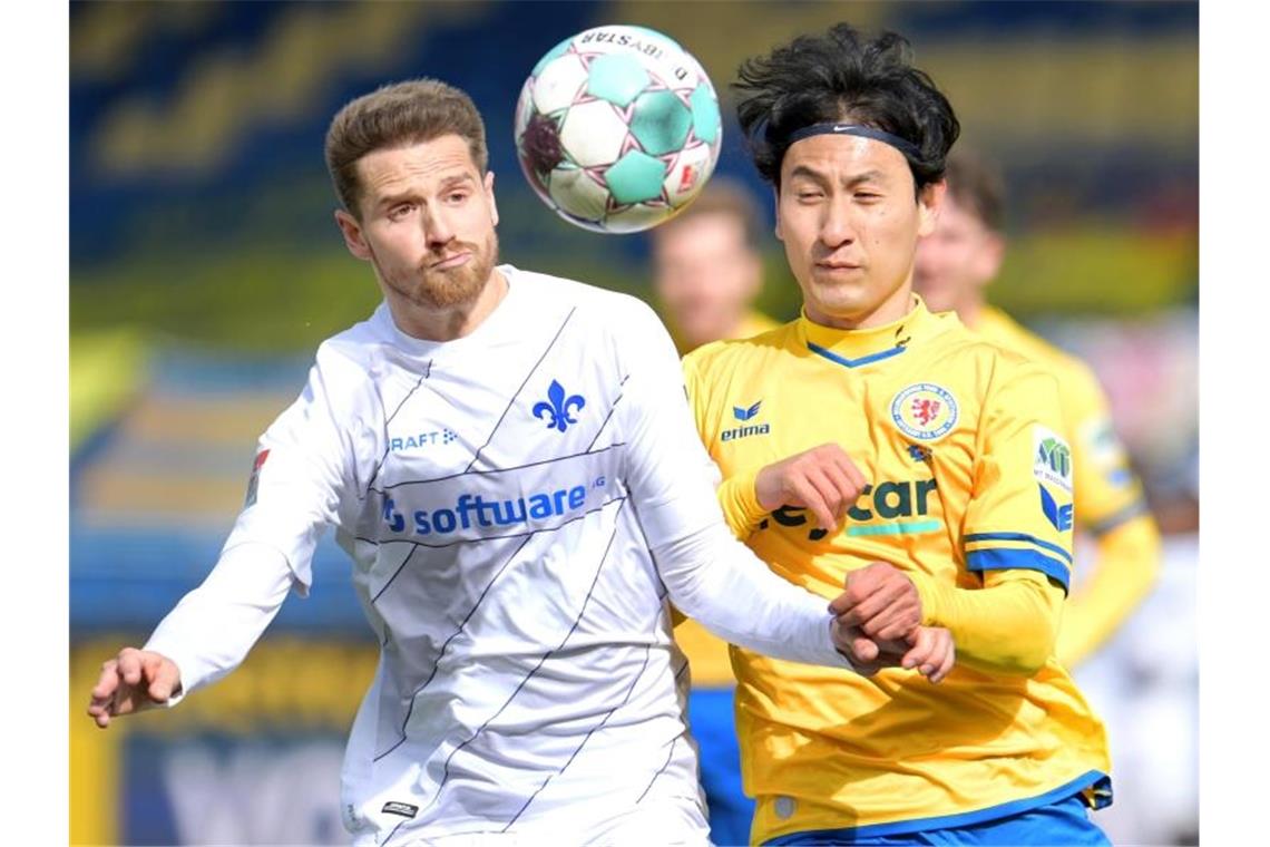 Darmstadts Immanuel Höhn und Braunschweigs Dong-won Ji kämpfen um den Ball. Foto: Hauke-Christian Dittrich/dpa/Archivbild