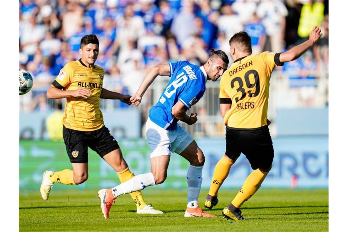 Darmstadts Serdar Dursun ist von den beiden Dynamo-Akteuren Jannis Nikolaou (l) und Dresdens Kevin Ehlers (r) umstellt. Foto: Uwe Anspach