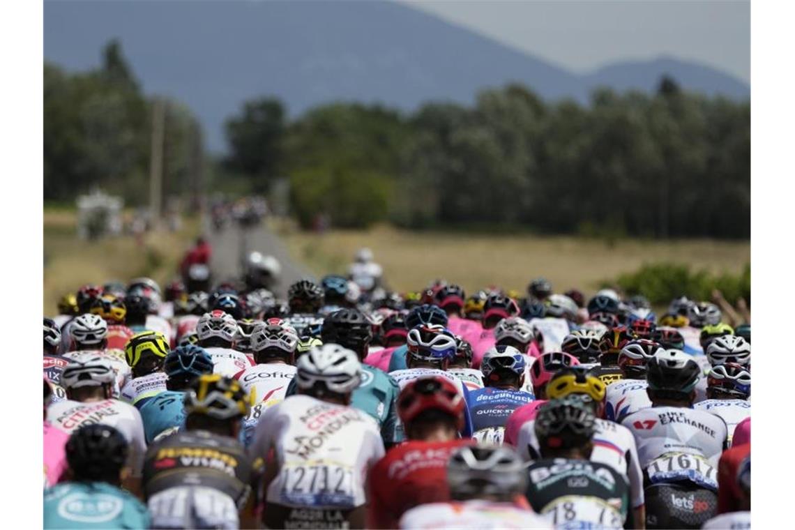 Van Aert gewinnt Ventoux-Etappe der Tour de France Das am Anfang noch eng zusammen fahrende Feld nähert sich dem „kahlen Riesen“ der Provence. Foto: Daniel Cole/AP/dpa