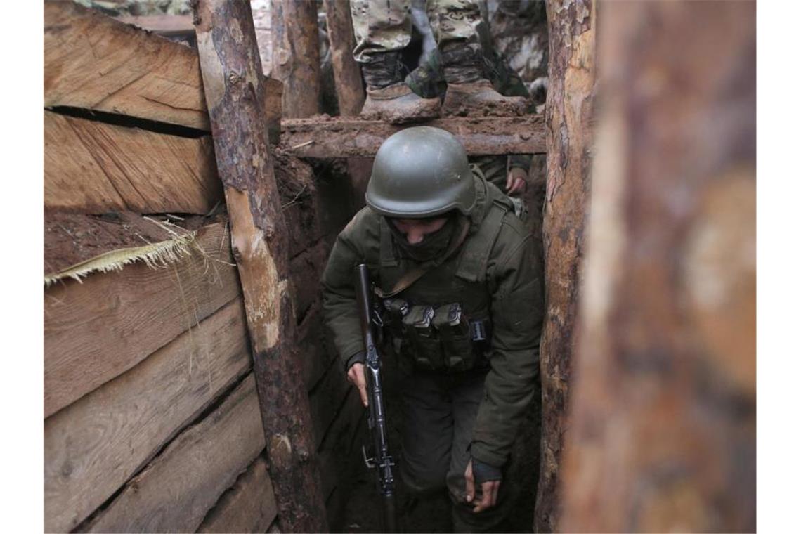 Ostukraine: Waffenruhe trotz neuer Spannungen in Kraft Das Archivbild zeigt einen ukrainischen Soldaten im Dezember 2019 in einem Schützengraben an der Front in der Region Donezk. Foto: Vitali Komar/AP/dpa