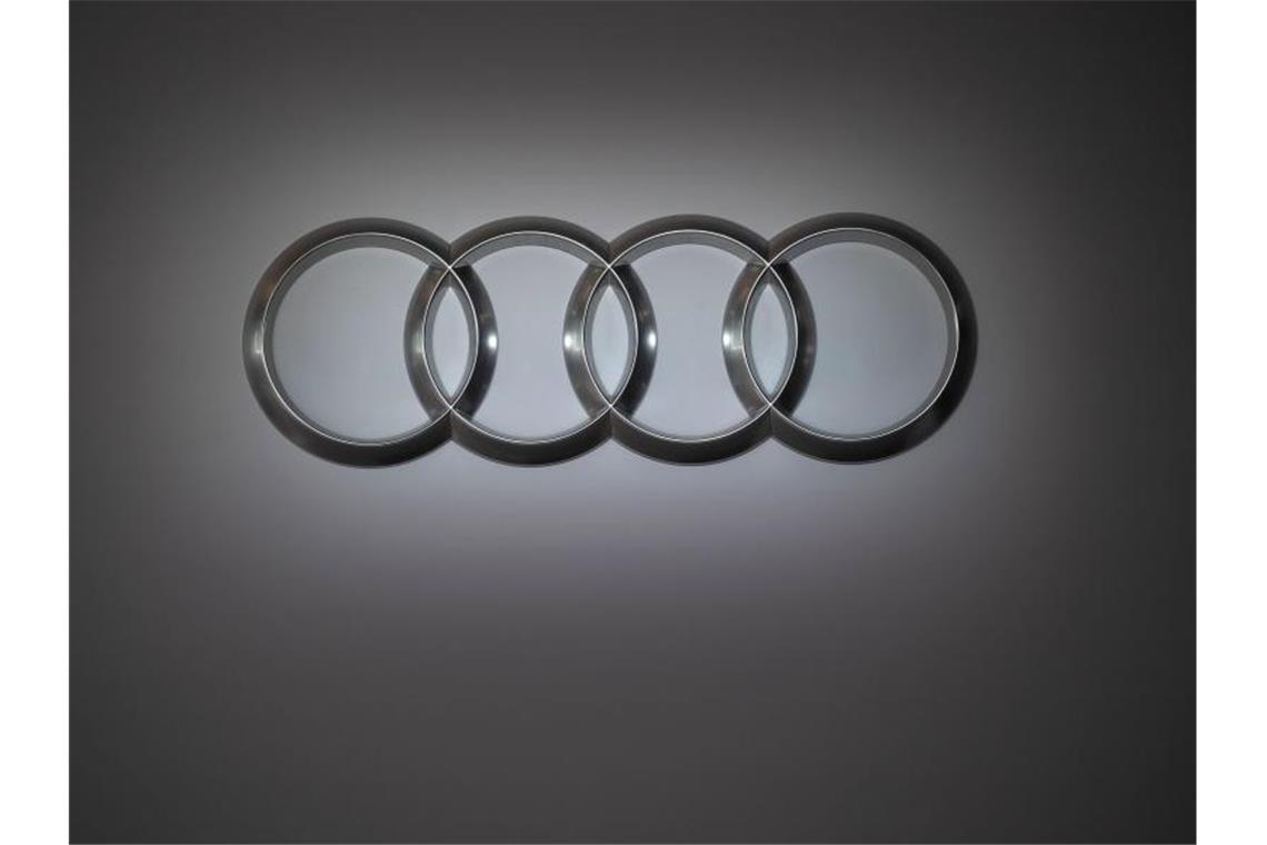 Das Audi-Logo zeigt vier miteinander verbundene Kreise vor dem Hintergrund einer grauen Wand. Foto: Marijan Murat/dpa/Archivbild