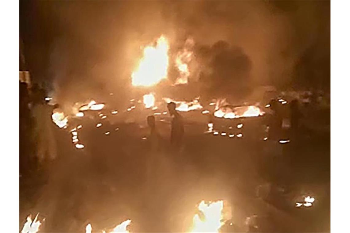 Mindestens 97 Tote nach Explosion in Sierra Leone Das aus einem Video stammende Standbild zeigt Personen, die durch brennende Trümmer in Freetown gehen. Foto: Uncredited/AP/dpa