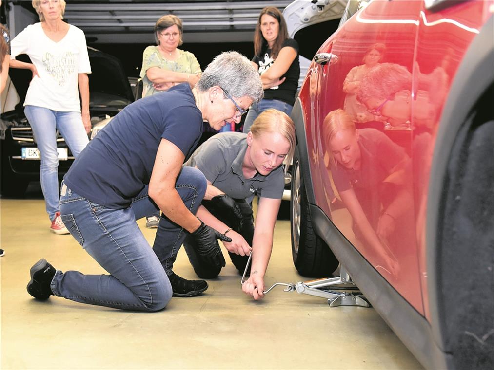 Selbst ist die Frau Das Auto aufzubocken, ist ein Kraftakt, weiß Nathalie Hofmann (vorne rechts). Sie zeigt Karin Rausch, wie es geht. Fotos: T. Sellmaier