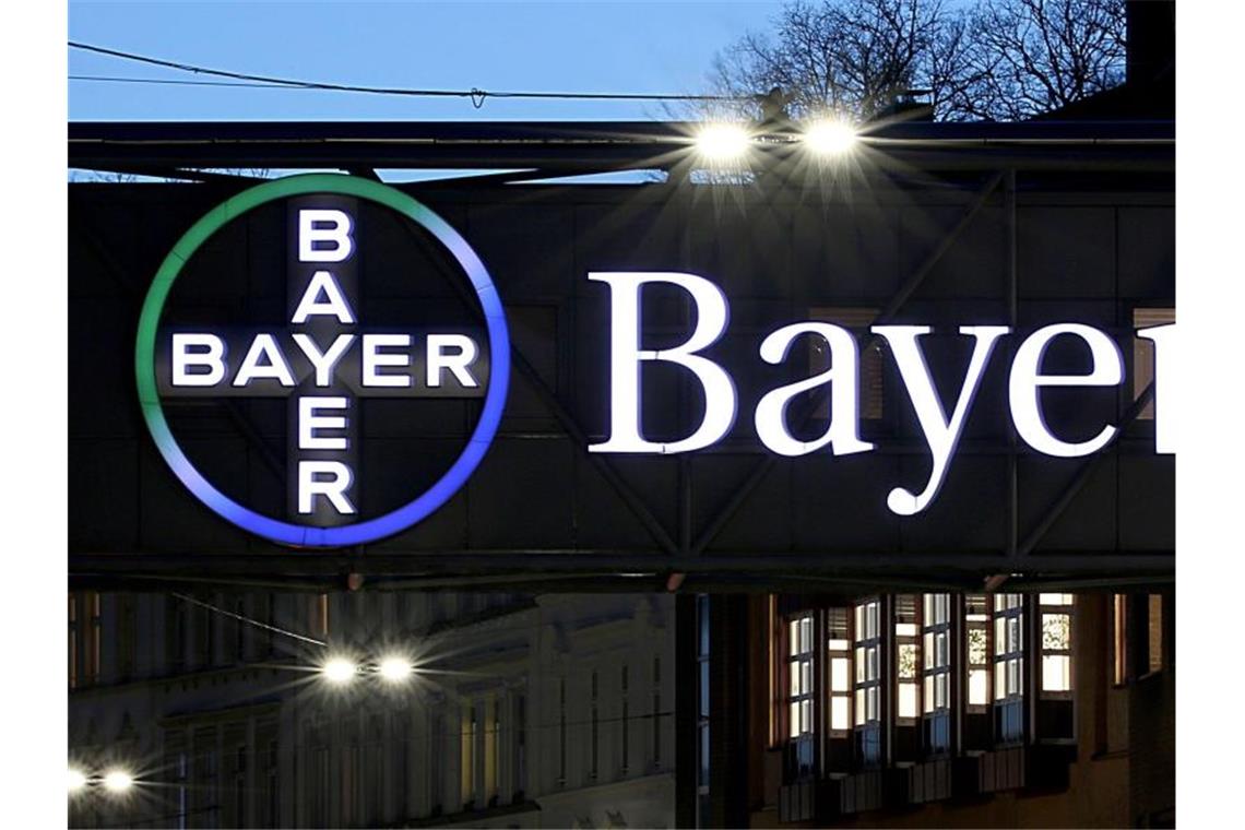 Das Bayer-Kreuz am Werk in Wuppertal leuchtet in der Dämmerung. Foto: Oliver Berg/dpa
