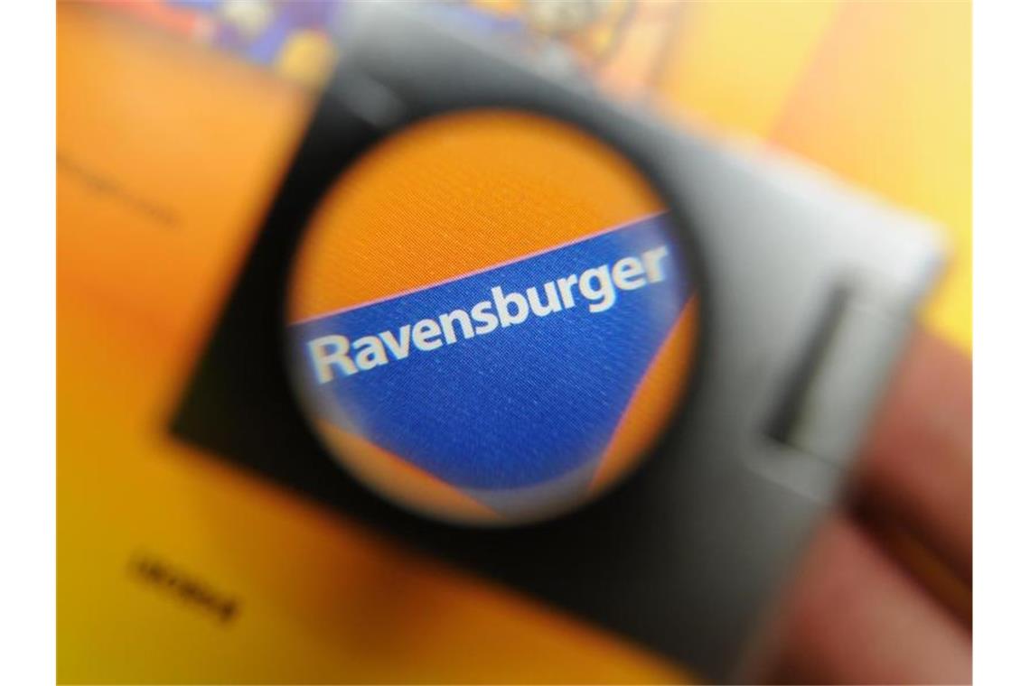 Kugelbahn bringt Ravensburger Wachstum Das blaue Dreiecks-Logo ist beim Spielehersteller Ravensburger AG in Ravensburg durch eine Lupe zu sehen. Foto: Felix Kästle/Archiv