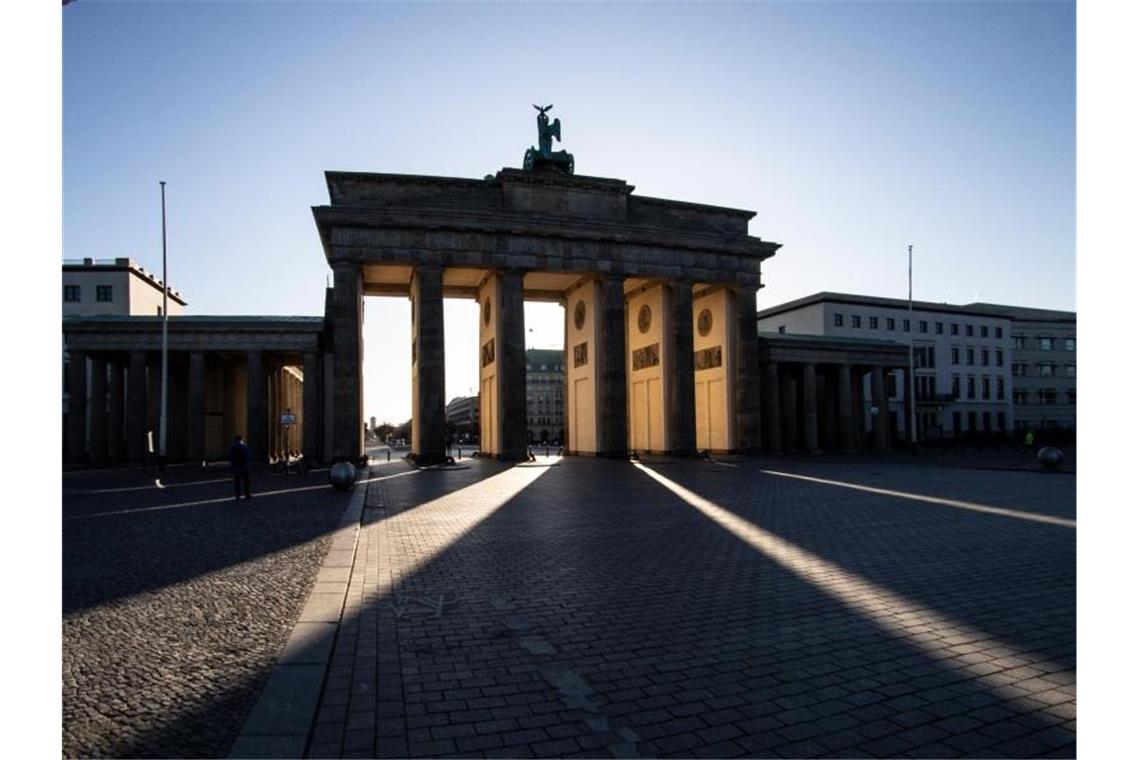 Das Brandenburger Tor im Licht der aufgehenden Sonne. Foto: Paul Zinken/dpa