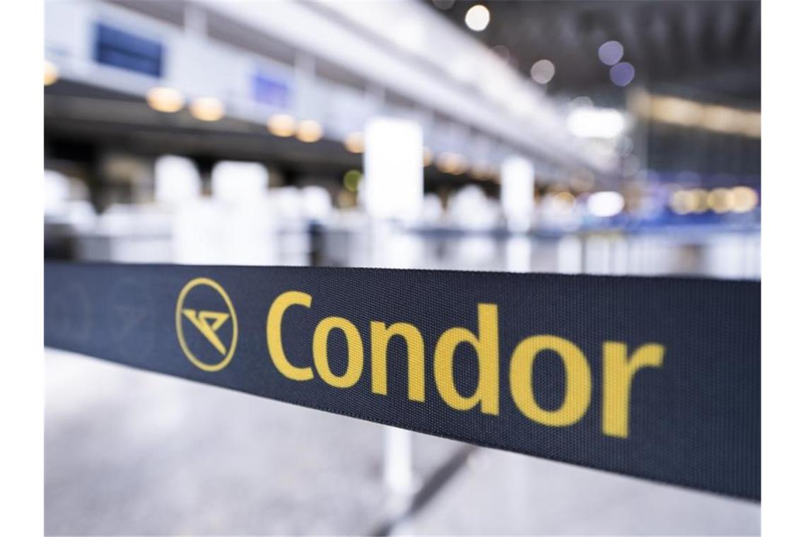 Das Condor-Logo auf einem Absperrband vor einem geschlossenen Schalter. Foto: Silas Stein/dpa