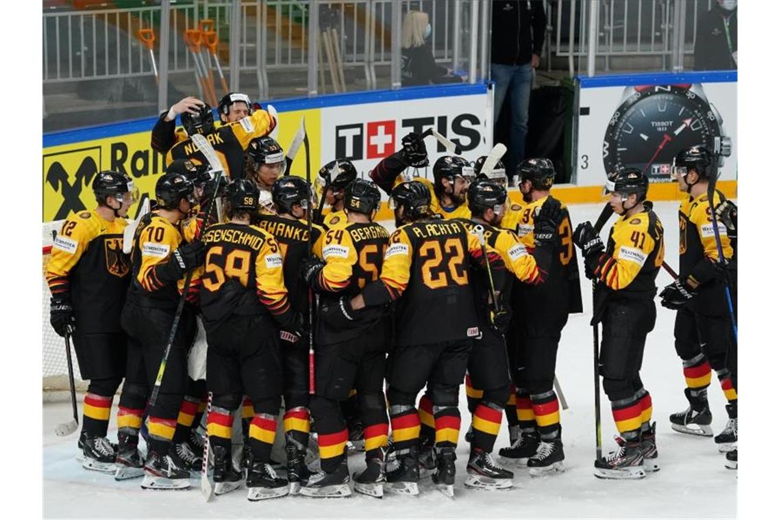 Das deutsche Nationalteam steht jubelnd nach dem Spiel auf dem Eis, nachdem es mit einem Sieg gegen Gastgeber Lettland das WM-Viertelfinale erreicht hat. Foto: Roman Koksarov/dpa