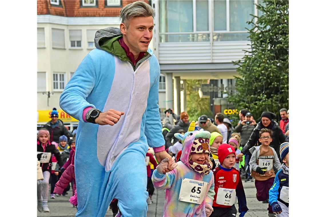 Das Einhorn Emilie läuft an Papas Hand den Bambinilauf. Silvesterlauf in Backnan...