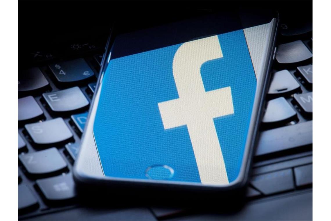 Das Facebook-Logo wird auf einem Smartphone gespiegelt, das auf einer Tastatur liegt. Foto: Dominic Lipinski/PA Wire/Archiv