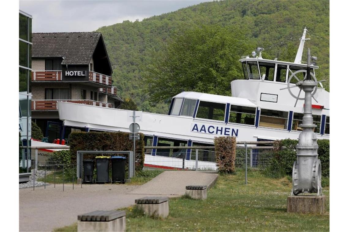 Das Fahrgastschiff "Aachen" liegt am Ufer des Rursees vor einem Hotel auf dem Trockenen. Foto: Oliver Berg/dpa
