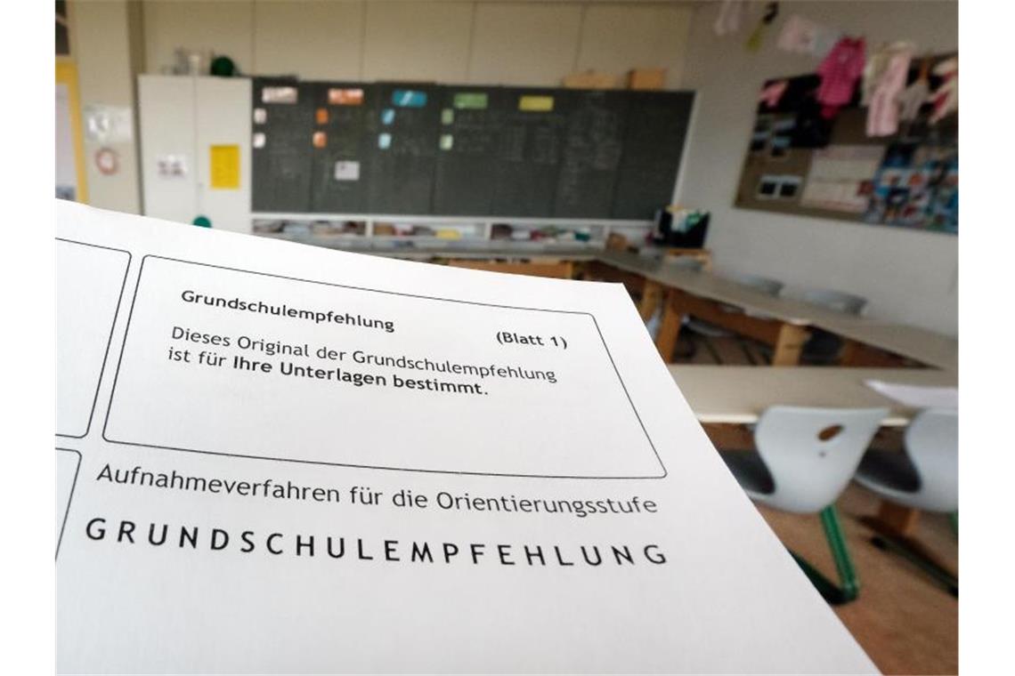 Das Formular einer Grundschulempfehlung wird in einem Klassenzimmer einer Grundschule gehalten. Foto: Bernd Weissbrod/dpa/Illustration