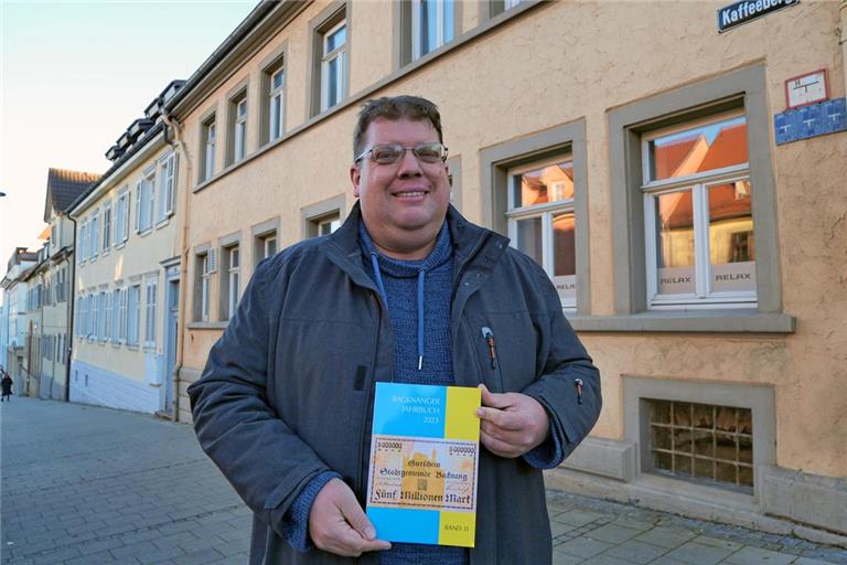 Das Foto zeigt Carsten Kottmann mit dem Jahrbuch am Kaffeeberg in Ludwigsburg. In dieser Straße – früher Metzgerstraße – stand das Gebäude, in dem der Mord geschehen ist. Foto: Armin Fechter