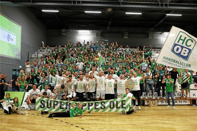 Das HCOB-Team mit einem Teil der Fans, die in Hildesheim für lautstarke Unterstützung sorgen und damit ihren Anteil am Sprung in die 2. Bundesliga haben. Foto: Alexander Becher