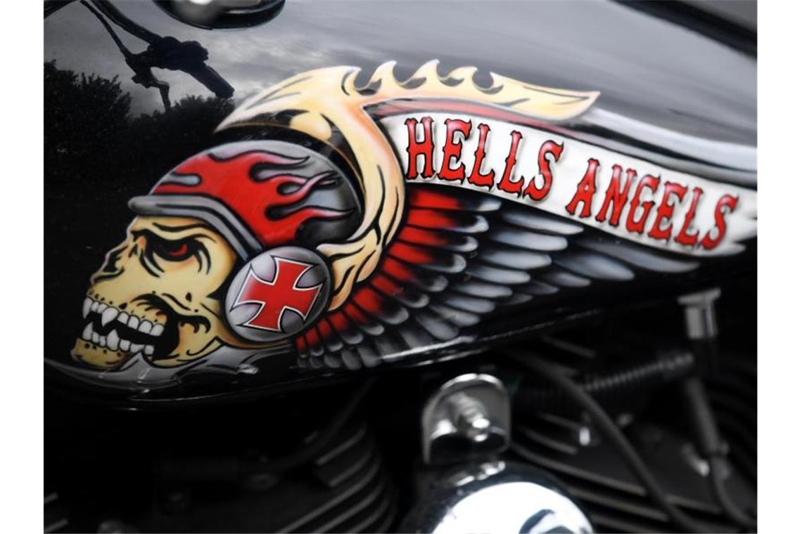 Das Hells Angels-Emblem, ein Totenkopf mit Helm und Flügeln, auf einem Tank eines abgestellten Motorrads. Foto: picture alliance / Arne Dedert/dpa