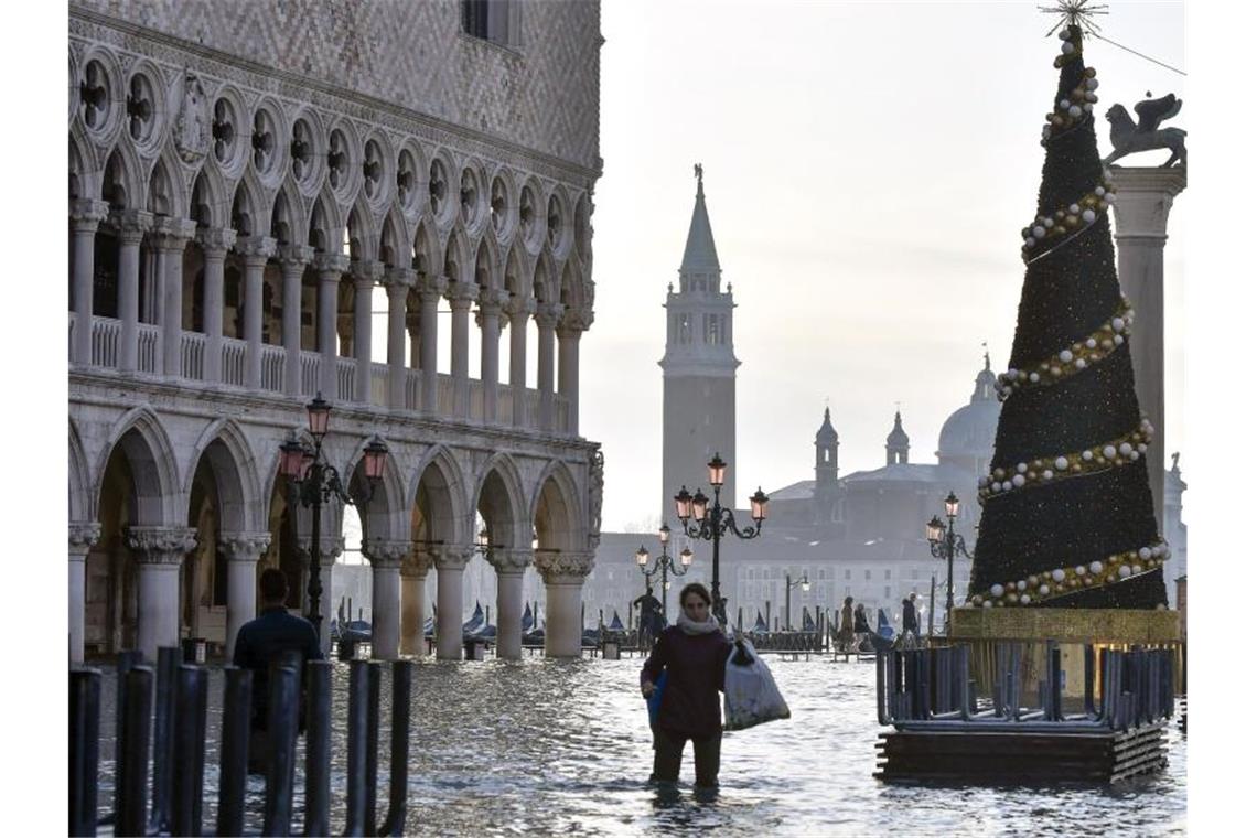 Hochwasserpegel in Venedig weiterhin hoch Das Hochwasser ist zurück: Eine Frau watet über den überfluteten Markusplatz. Foto: Luigi Costantini/AP/dpa