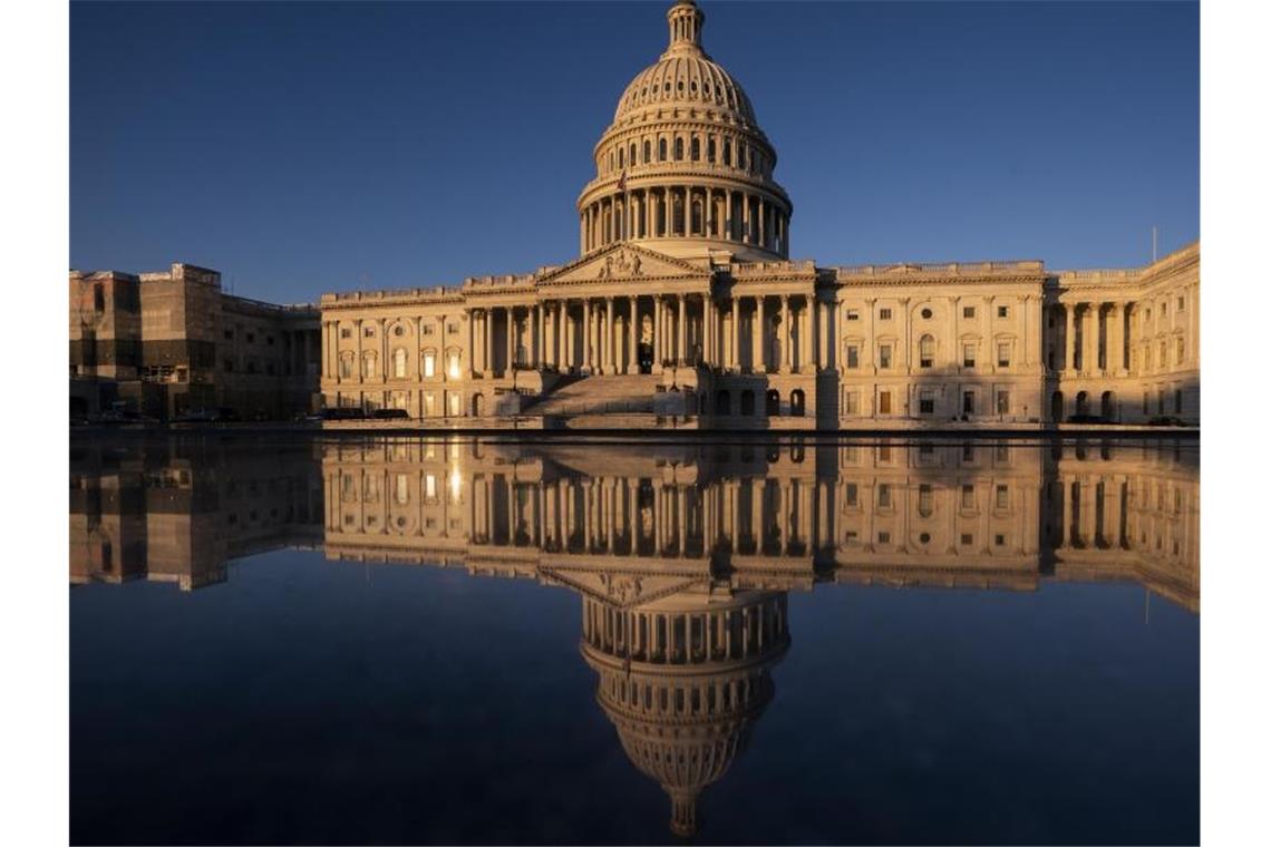 Das Kapitol der USA spiegelt sich in Wasser während des Sonnenaufgangs. Foto: J. Scott Applewhite/AP/dpa
