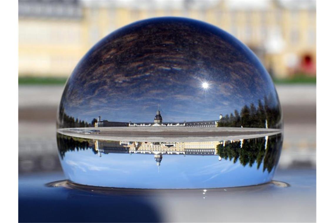 Schlosslichtspiele feiern „Sommer der Liebe und des Lebens“ Das Karlsruher Schloss spiegelt sich in einer Glaskugel wider. Foto: Uli Deck/Archivbild