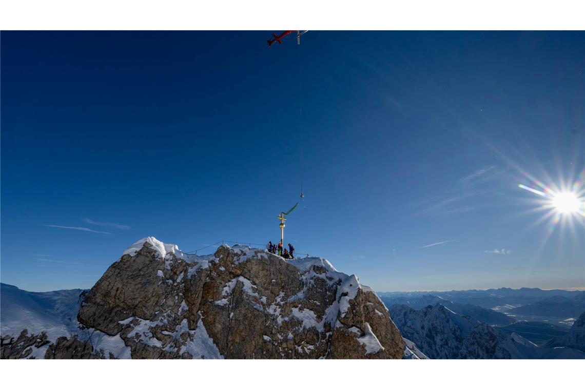 Das Kreuz schwebt am Gipfel ein.