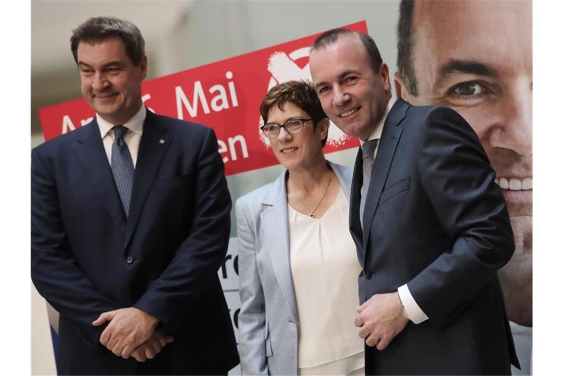 Nahles stellt sich Neuwahl als Fraktionschefin Das Lächeln wirkt eher angestrengt: Der CSU-Vorsitzende Markus Söder (l), CDU-Chefin Annegret Kramp-Karrenbauer und Manfred Weber, Spitzenkandidat der Union, äußern sich zu den Wahlergebnissen. Foto: Michael Kappeler